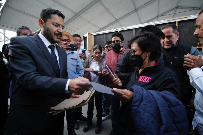 El presidente López Obrador firma un documento ante la prensa.