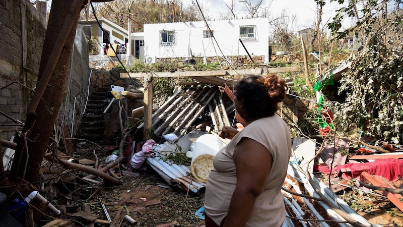 Mujer inspecciona los daños causados por el huracán en su casa