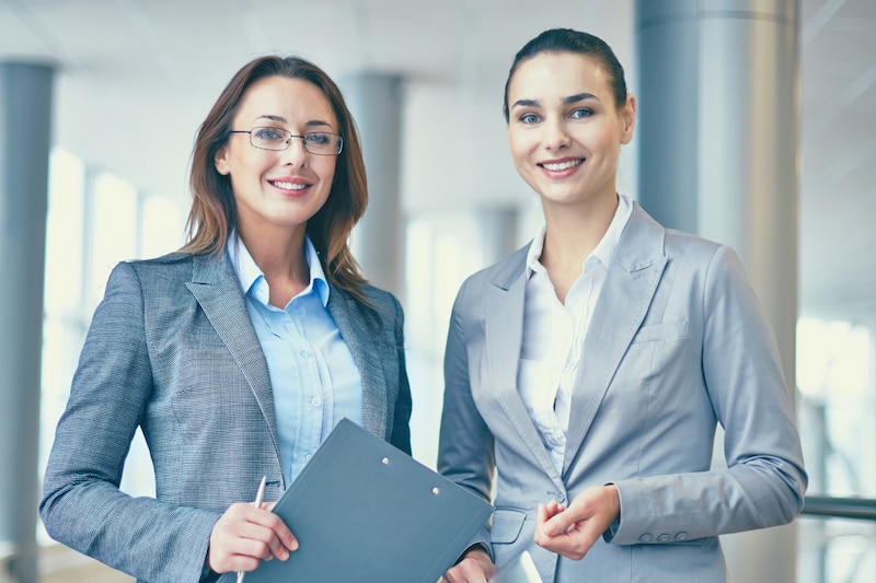 Dos mujeres ejecutivas del Sector Salud sonriendo