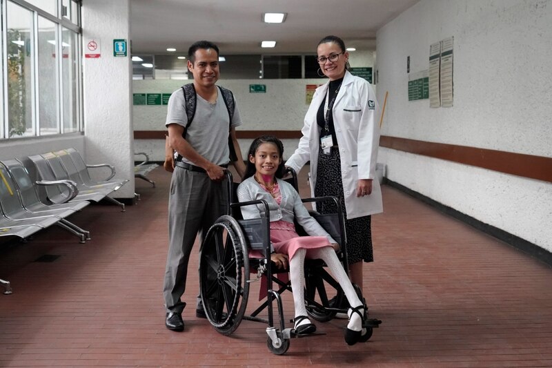 Paciente con discapacidad en silla de ruedas con su familia en el hospital