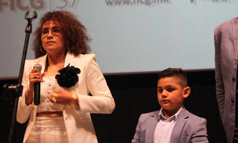 La cantante Yuridia con un niño en un evento