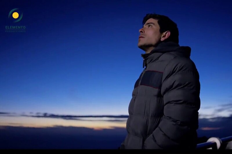 Un hombre mirando al cielo nocturno estrellado.