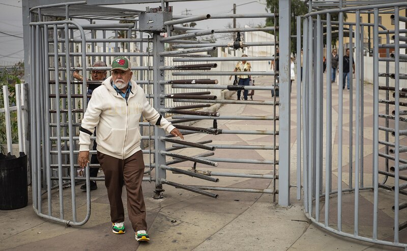 Personas de origen mexicoestadounidenses cruzan la frontera hacia México por la garita de San Isidro, este jueves, en la ciudad de Tijuana, estado de Baja California