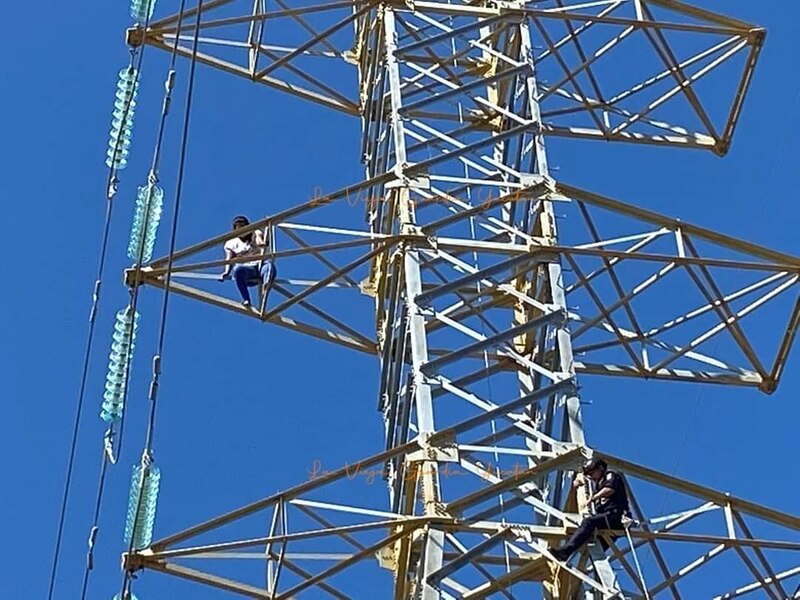 Dos hombres trepan a una torre de alta tensión