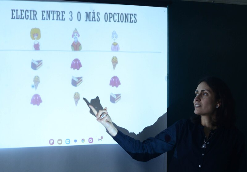 Profesora dando clase en una pizarra digital