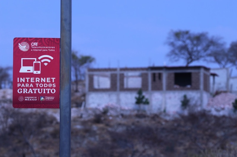 Anuncio del programa "Internet para todos gratuito" de la Comisión Federal de Electricidad colocando en una calle de la comunidad de Chinameca