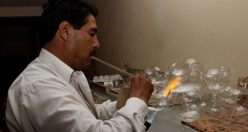Artesano mexicano soplando vidrio
