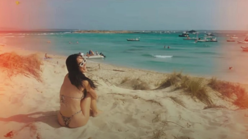 Mujer en bikini tomando el sol en la playa