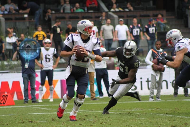 Tom Brady, el mariscal de campo de los Patriots de Nueva Inglaterra, corre con el balón durante un partido de fútbol americano.