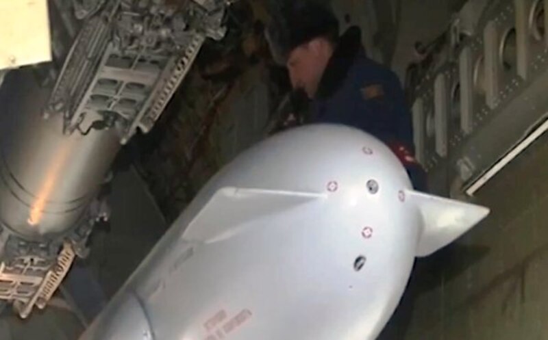 Un soldado carga una bomba nuclear en un avión.