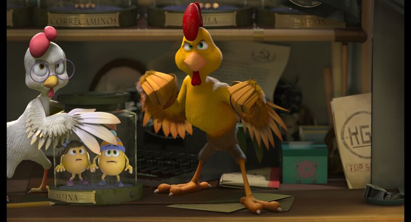 Dos pollos miran sorprendidos a otro pollo que está encima de una mesa con cara de enfado