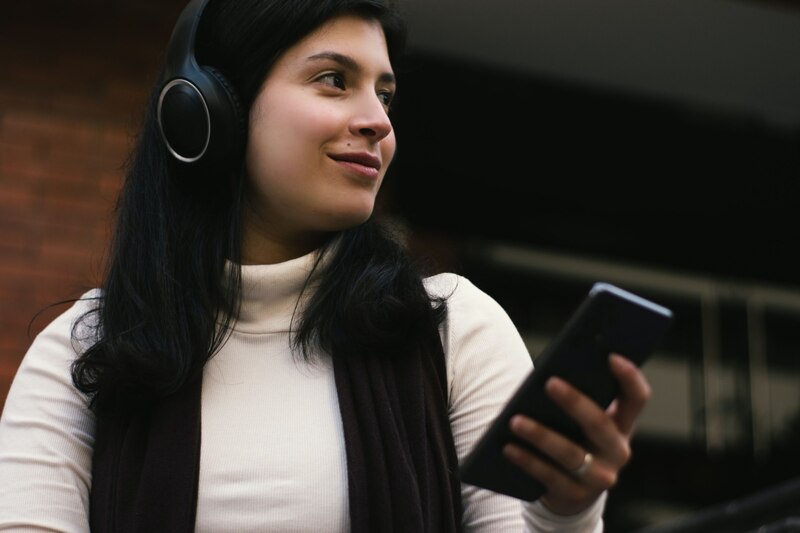 Mujer joven escuchando música con auriculares