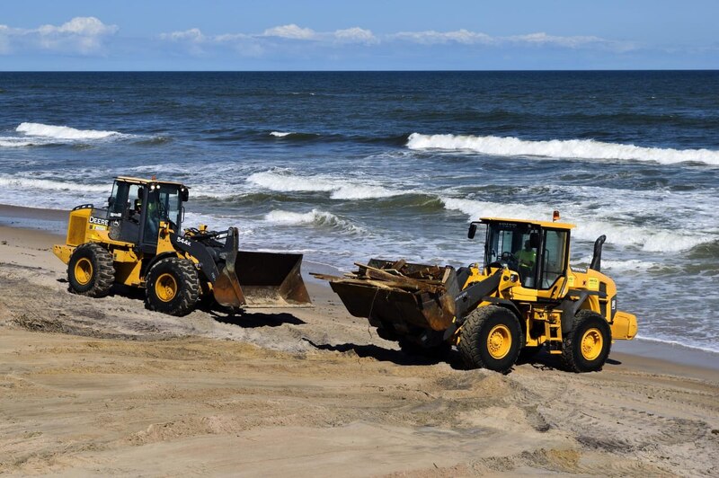 Dos excavadoras trabajan en la limpieza de una playa