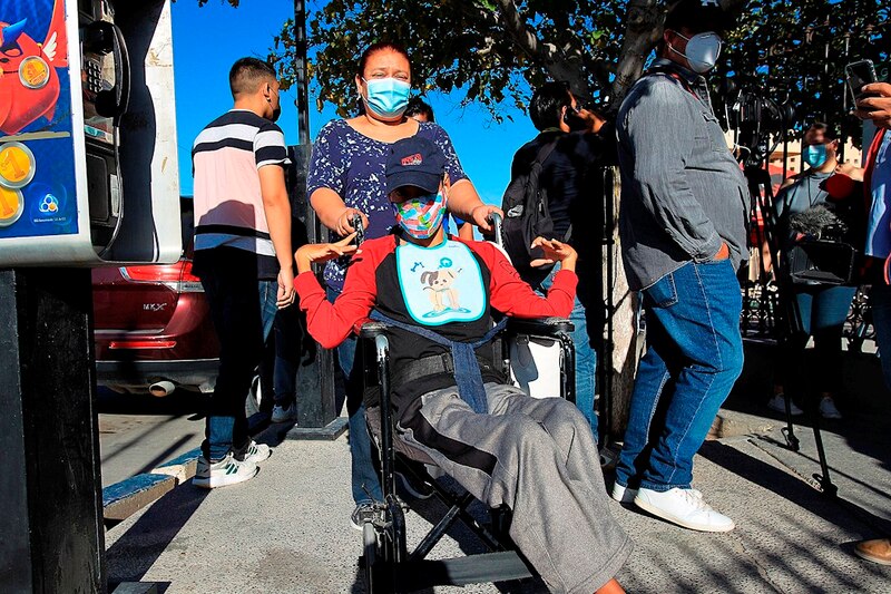 Mujer en silla de ruedas con una cuidadora