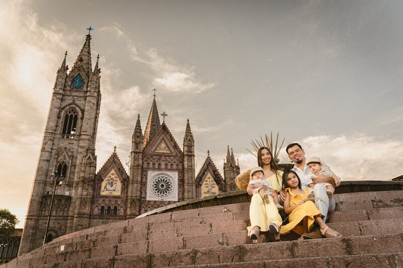 Familia feliz sentada en las escaleras de una iglesia