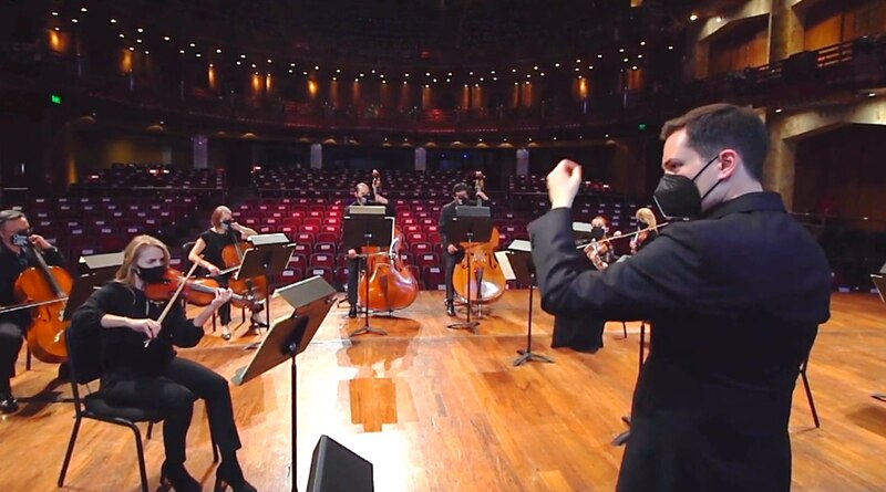 Orquesta sinfónica tocando en un teatro