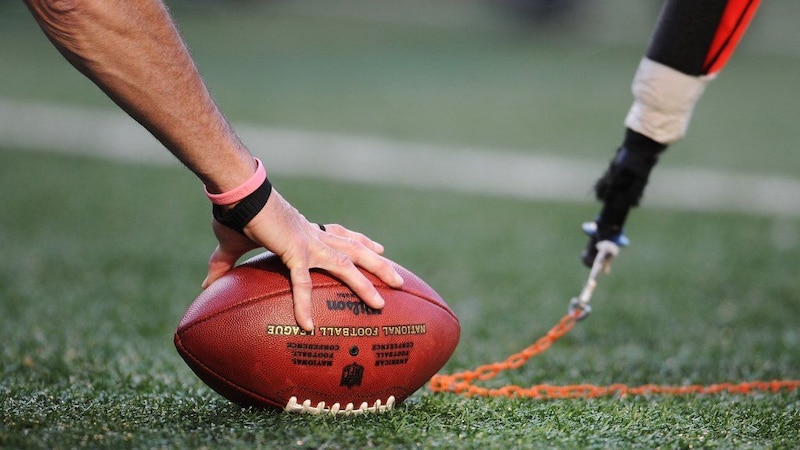 Jugador de fútbol americano sujetando un balón con una cadena