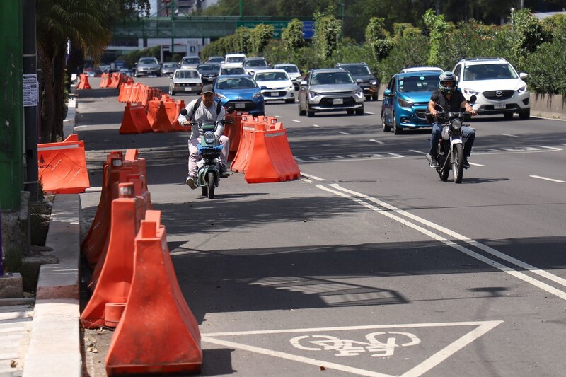 Una bicimoto circula por el carril piloto de la nueva ciclovía de Calzada de Tlalpan, ignorando las barreras para tráfico que fueron colocadas para delimitar el trayecto.