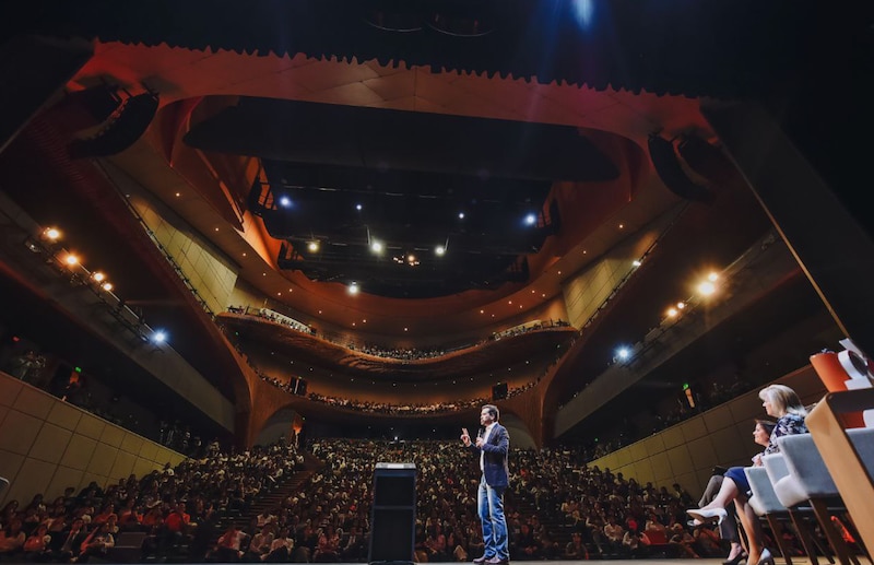 Un hombre da una conferencia en un auditorio.