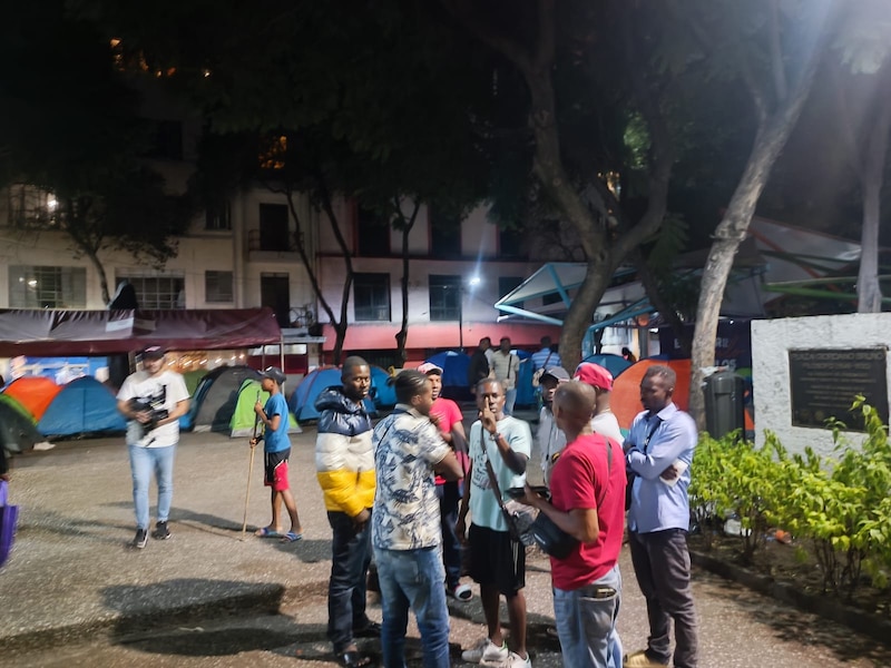 Un grupo de migrantes venezolanos conversa en una plaza pública de Bogotá.