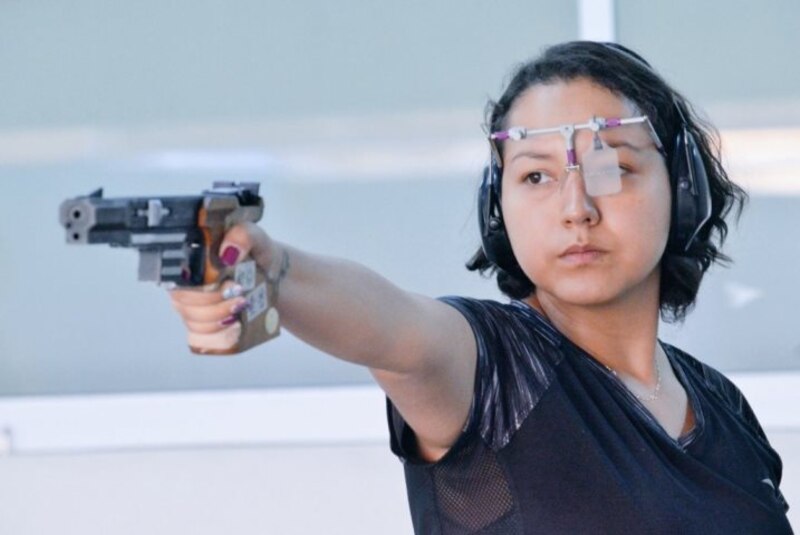 Mujer joven disparando una pistola