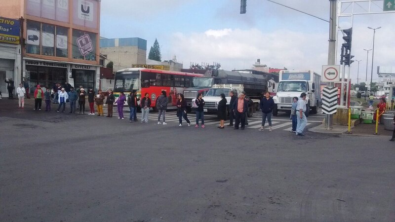 Multitud de personas cruza la calle en un cruce peatonal en la Ciudad de México