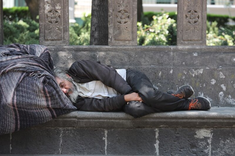 Un hombre sin hogar duerme en la calle