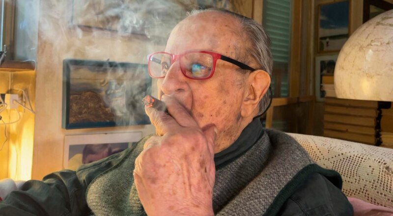 Un anciano fuma un puro
