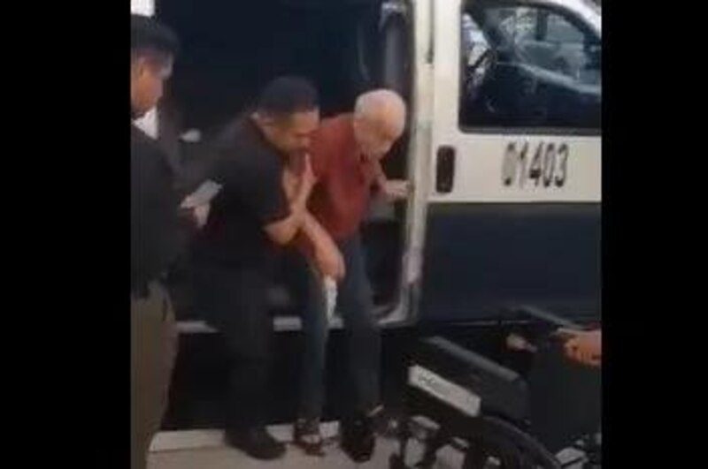 Un policía ayuda a un anciano a subir a una ambulancia