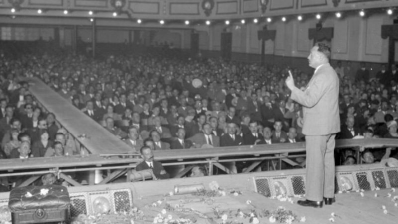 Un hombre dando un discurso en un teatro