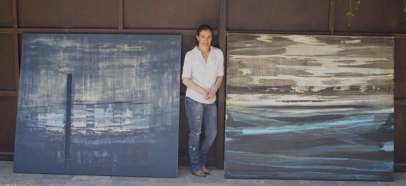 Artista posando junto a sus obras