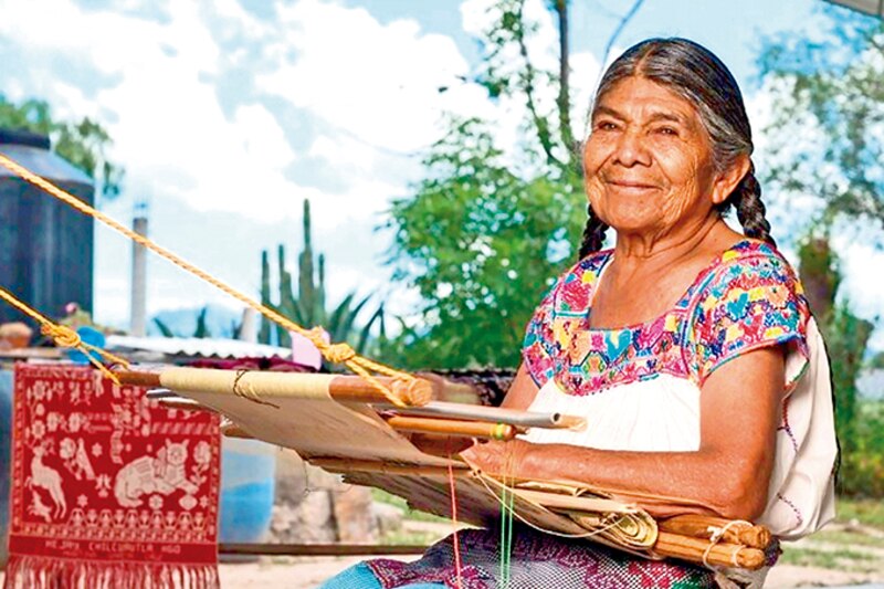 Mujer indígena tejiendo un huipil