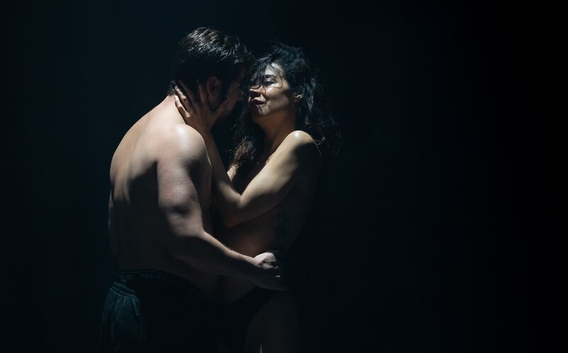 Pareja besándose apasionadamente en la oscuridad