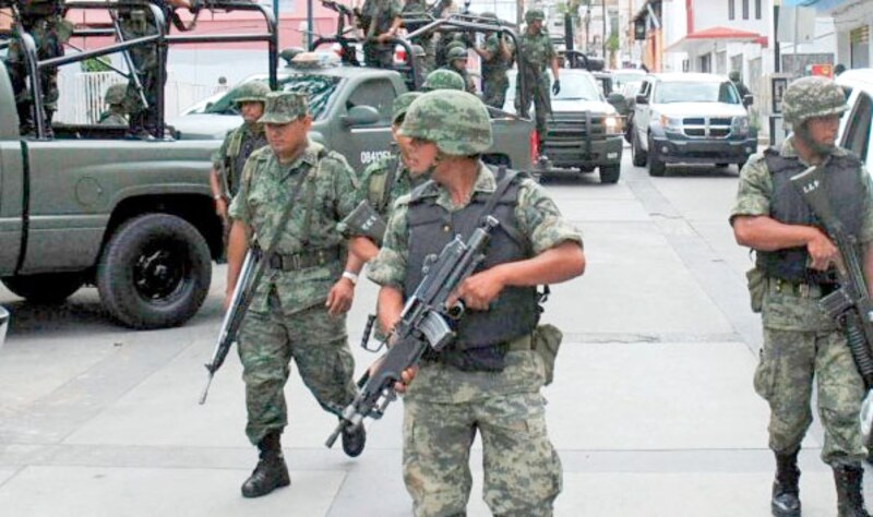 Militares mexicanos patrullan una calle en una ciudad mexicana.