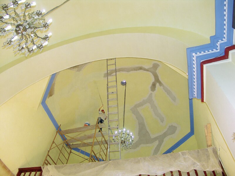 Pintor trabajando en el techo de una iglesia
