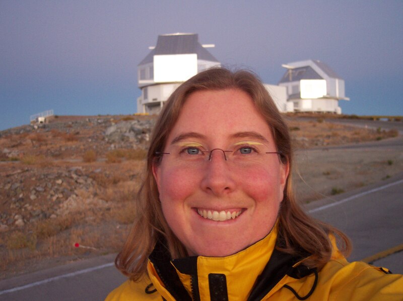 La astrofísica Dra. Ana María LLambias sonríe frente al telescopio