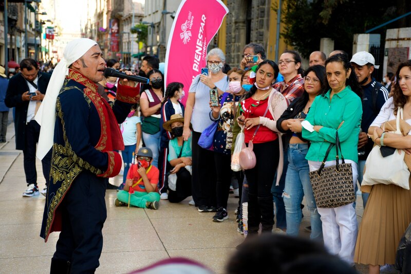Un cantante callejero entretiene a una multitud en una calle de la ciudad.