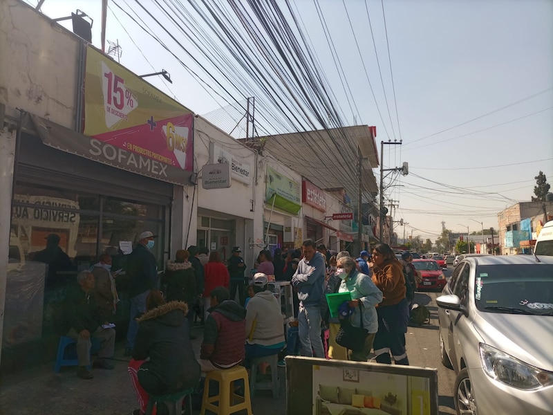 Larga fila de personas esperando para entrar a un banco en México