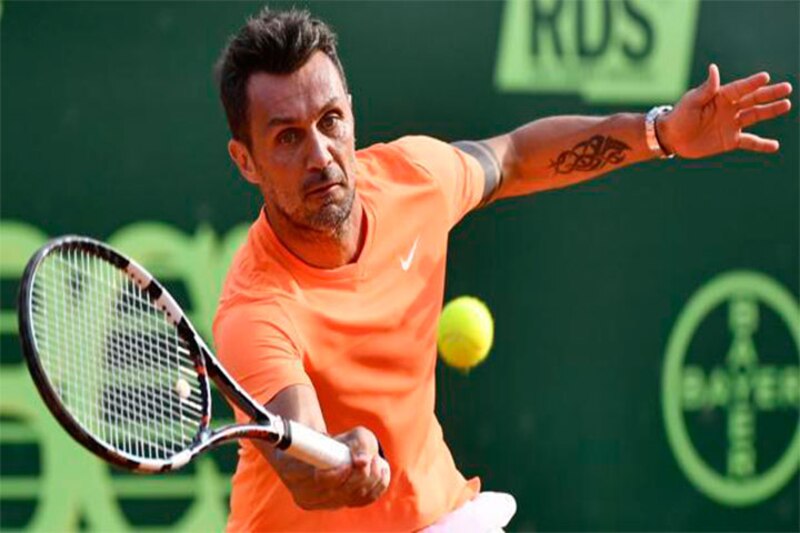El tenista español Feliciano López golpea una pelota de tenis con su raqueta.