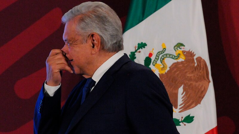 El presidente López Obrador se limpia la nariz durante una conferencia de prensa