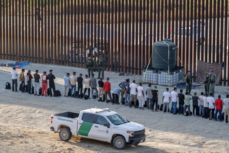 Migrantes esperan ser procesados por la Patrulla Fronteriza de EE.UU.