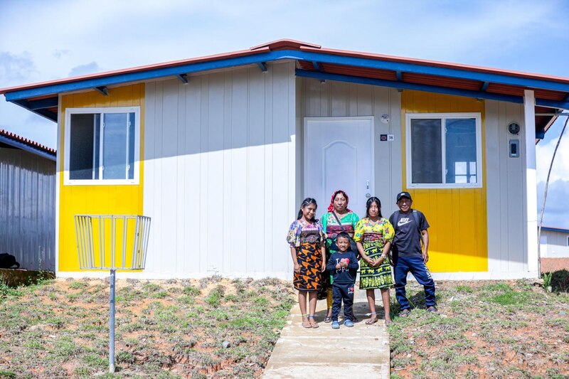 Familia feliz posando frente a su nueva casa