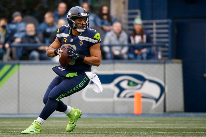 Russell Wilson, el mariscal de campo de los Seattle Seahawks, corre con el balón durante un partido de fútbol americano.