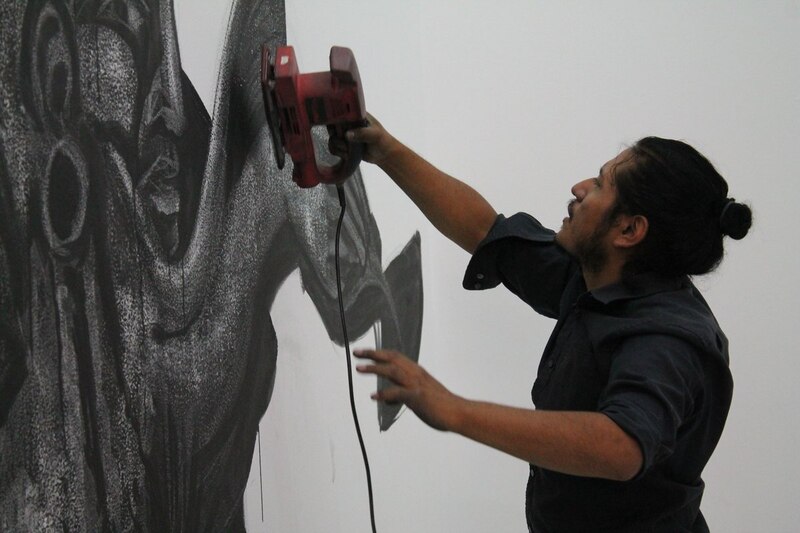 Artista lijando un mural de grafiti