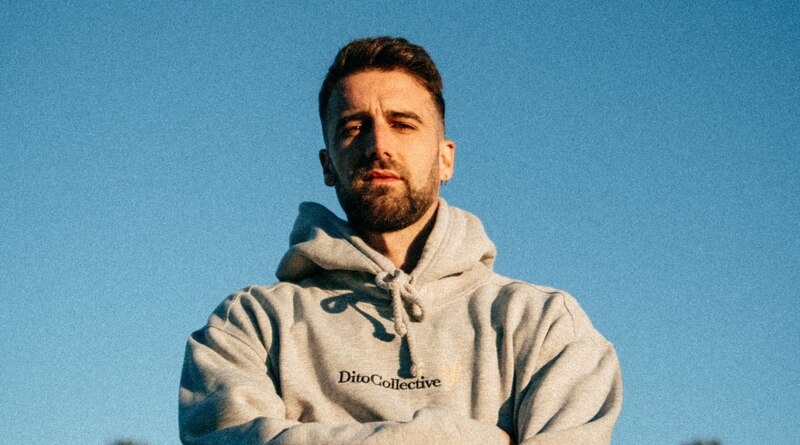 Retrato de un hombre joven con barba y sudadera gris