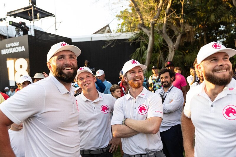 Golfistas profesionales sonríen y celebran en el green