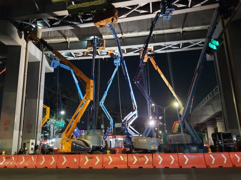 Trabajadores en plataformas elevadoras realizan tareas de mantenimiento en un puente