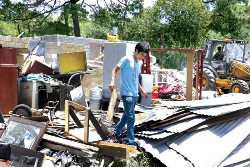 Un joven camina entre los escombros de una casa destruida
