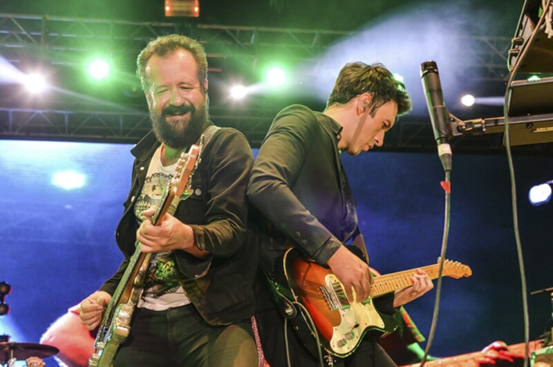 Dos hombres tocando la guitarra en un concierto