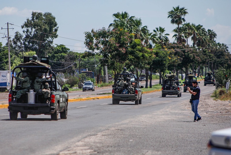 Militares mexicanos patrullan las calles de una ciudad.